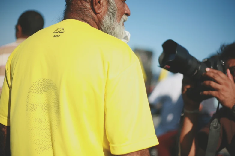 a man in yellow shirt talking to another man