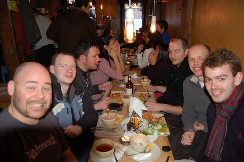 group of smiling people eating at the dining room