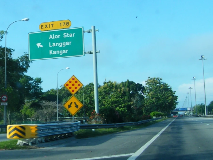 a green road sign above the highway exit