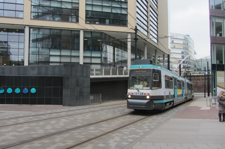 the tram is moving quickly on the tracks near buildings