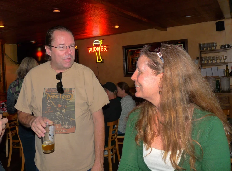 the man is talking to two women in a bar