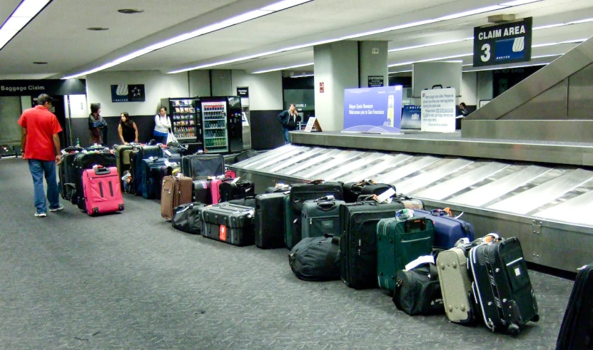 several people are walking by a very large area with suitcases