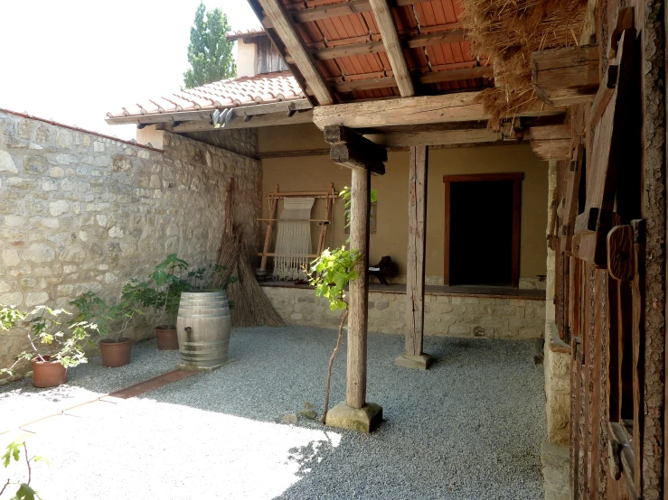 an outdoor courtyard is seen with a stone wall and door and patio
