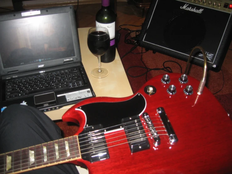 the guitar is next to a small laptop