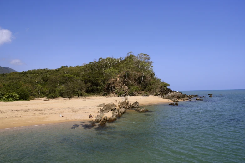 a lone beach in the middle of a body of water