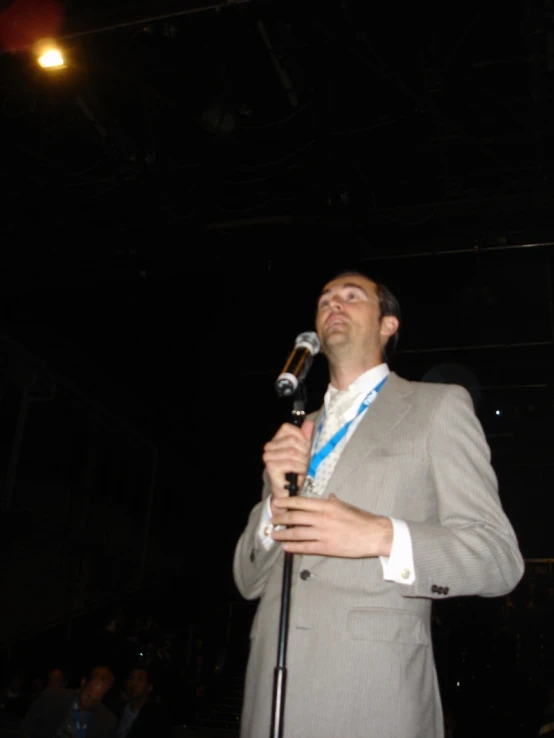 the man is standing at a microphone talking