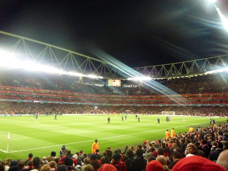 a large stadium with many people sitting and standing