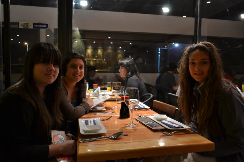 a group of girls sitting at a table posing for a po