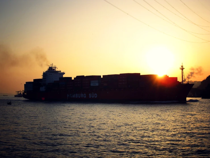 cargo ship with large cargo stacks passing in front