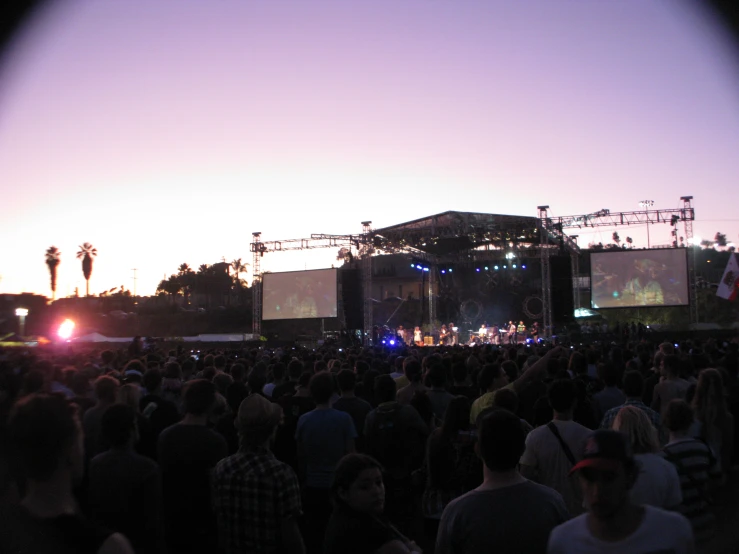 an event is seen from the rear with people in a darkened space around