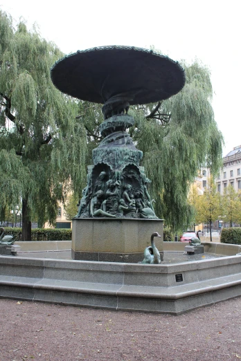 a statue in a park next to a water fountain