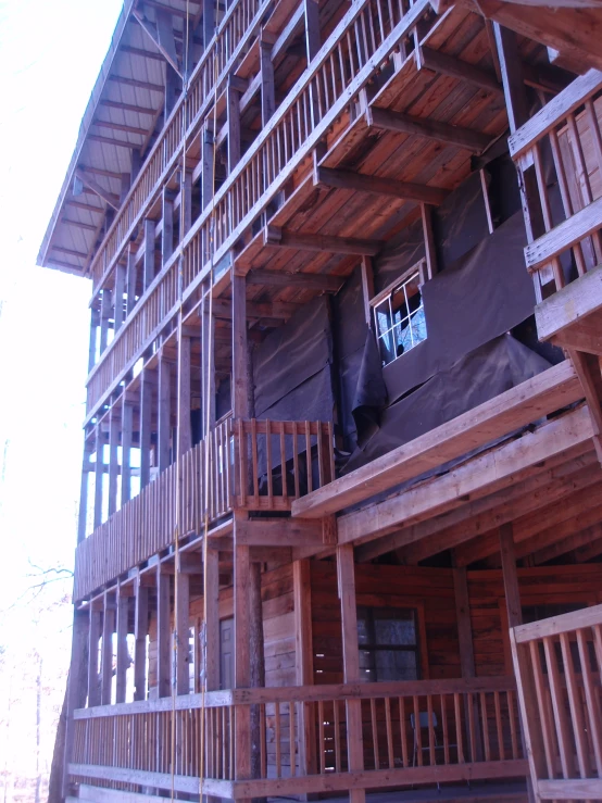 an open deck is below a large wooden house