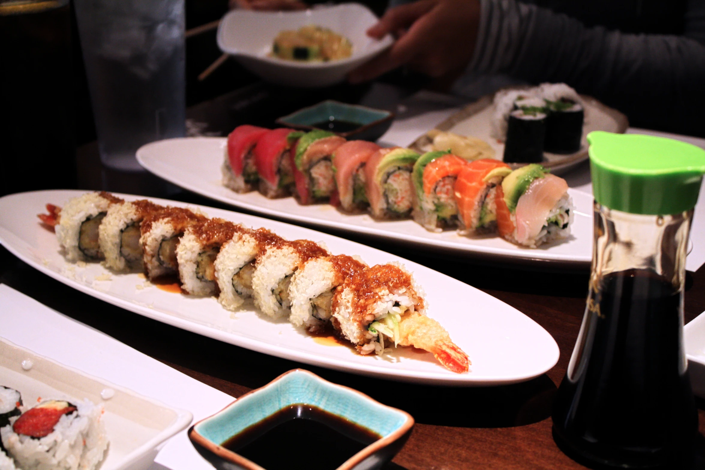 sushi are shown lined up on long white plates