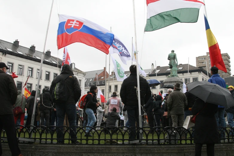 people holding flags are standing by a railing