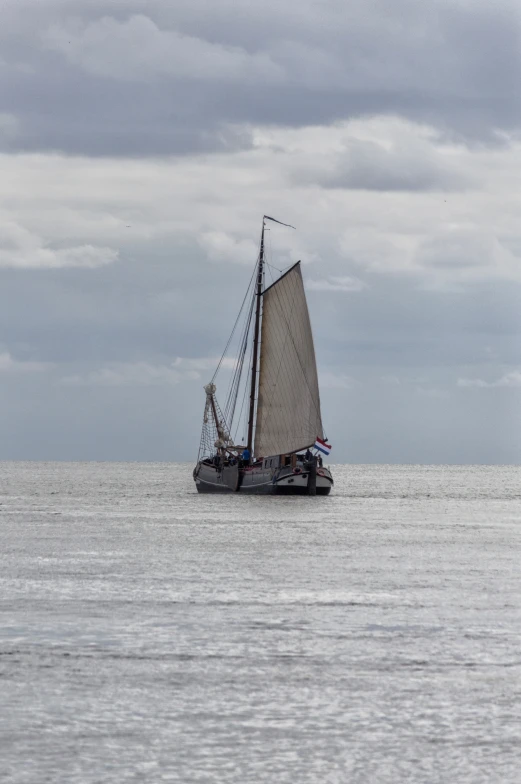 a boat with sails on a calm sea