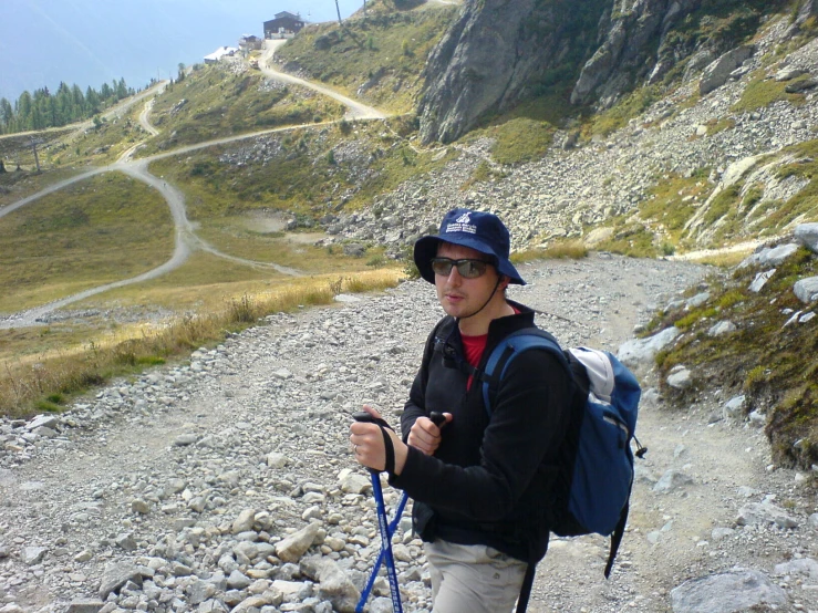 a man walking on a trail with a backpack