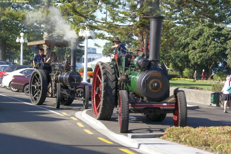 two people on a tractor are riding down the street