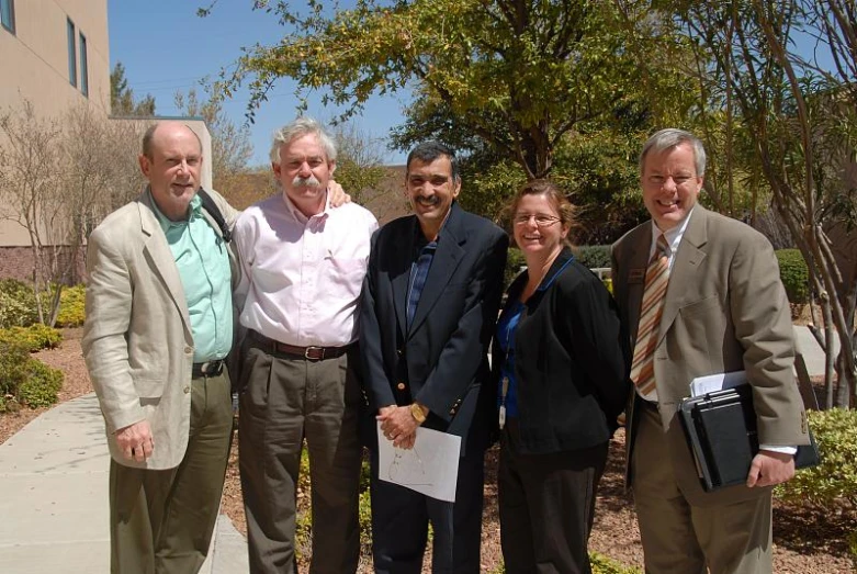 a group of people pose for a po outside