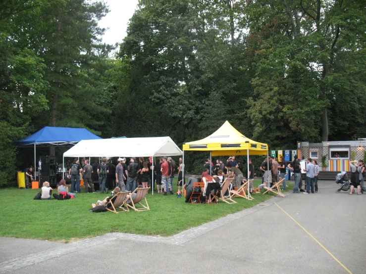 a group of people in line to get food at an outdoor festival