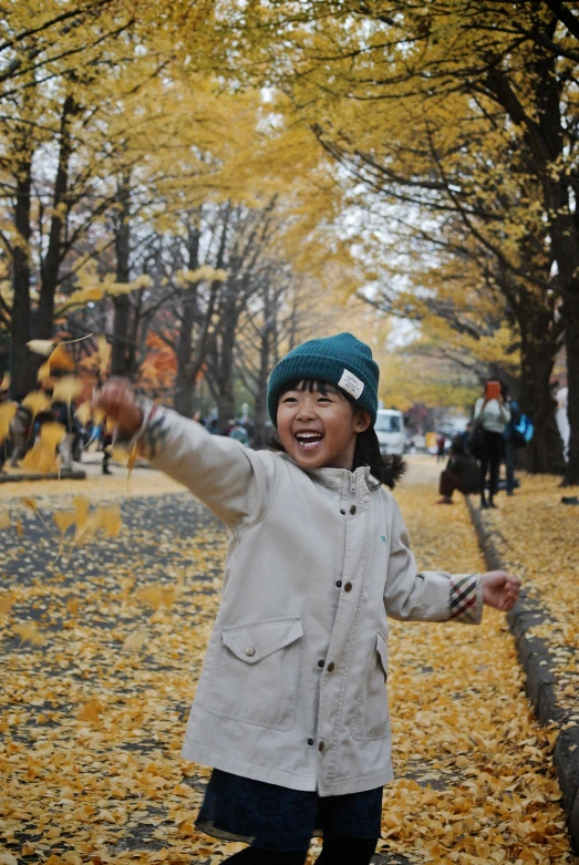 a little girl walking on the path with an umbrella in her hands