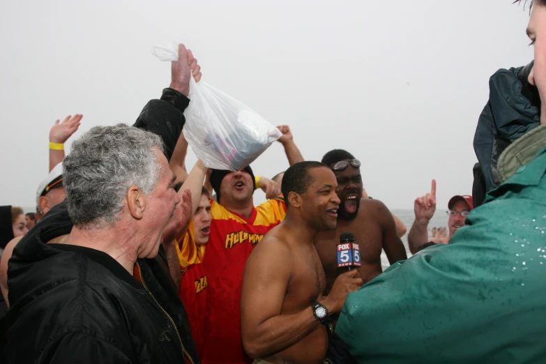 a group of people holding up bottles and papers