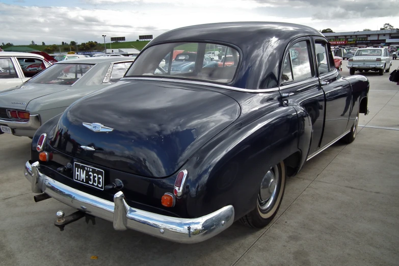 an old black classic car is parked outside