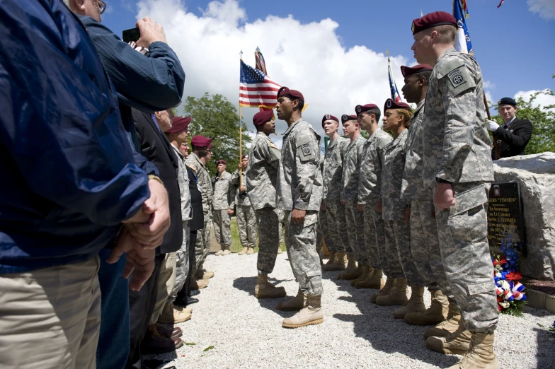 a group of soldiers standing in formation holding flags