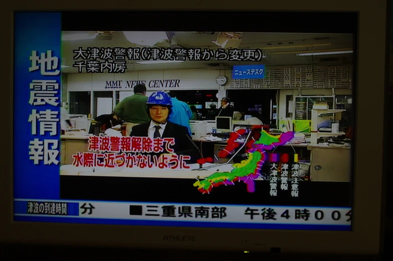 a tv screen displays a news program with asian writing