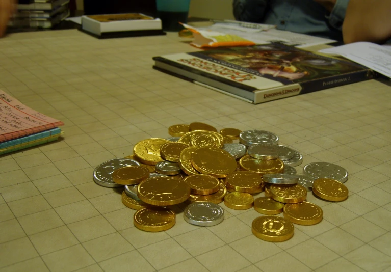 a table with lots of gold coins and books