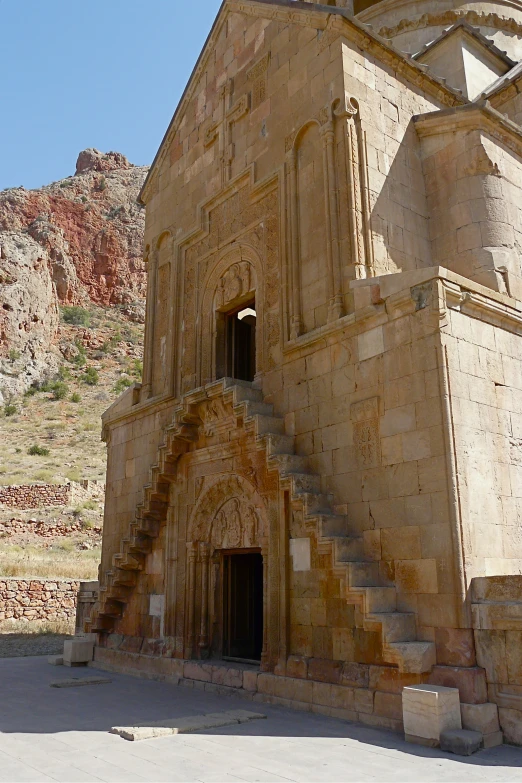 an ornate brick church in front of a mountain