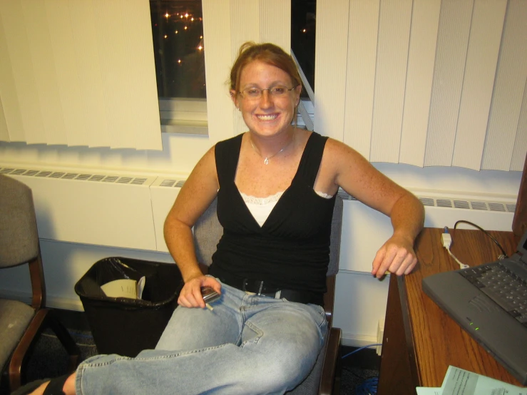 a woman sitting on a chair near a desk