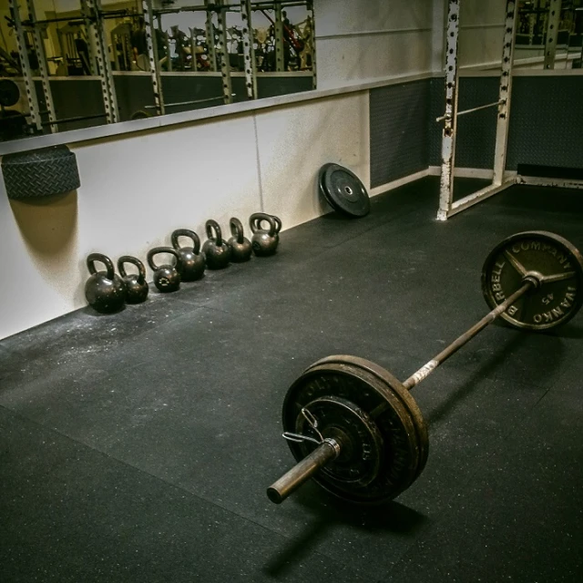 some weight plates on a black floor and dumbs