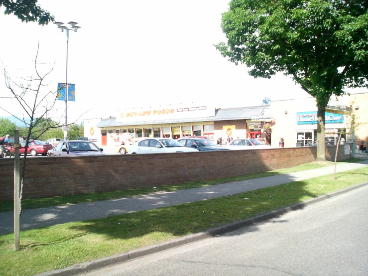 a sidewalk next to a street with cars parked nearby