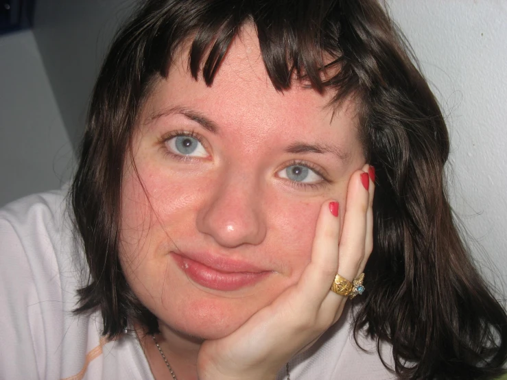 a woman with short hair and bright blue eyes smiles at the camera