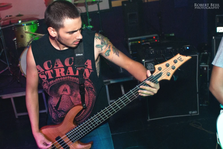 a man with a black shirt playing a bass