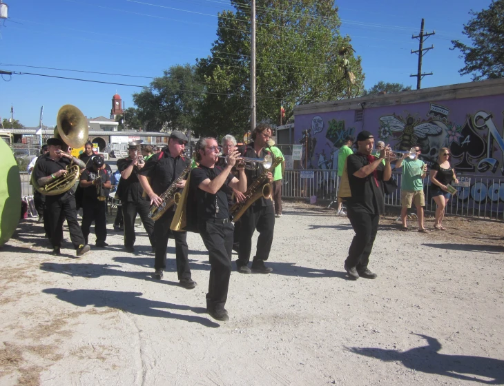 a band playing outside with a person in green