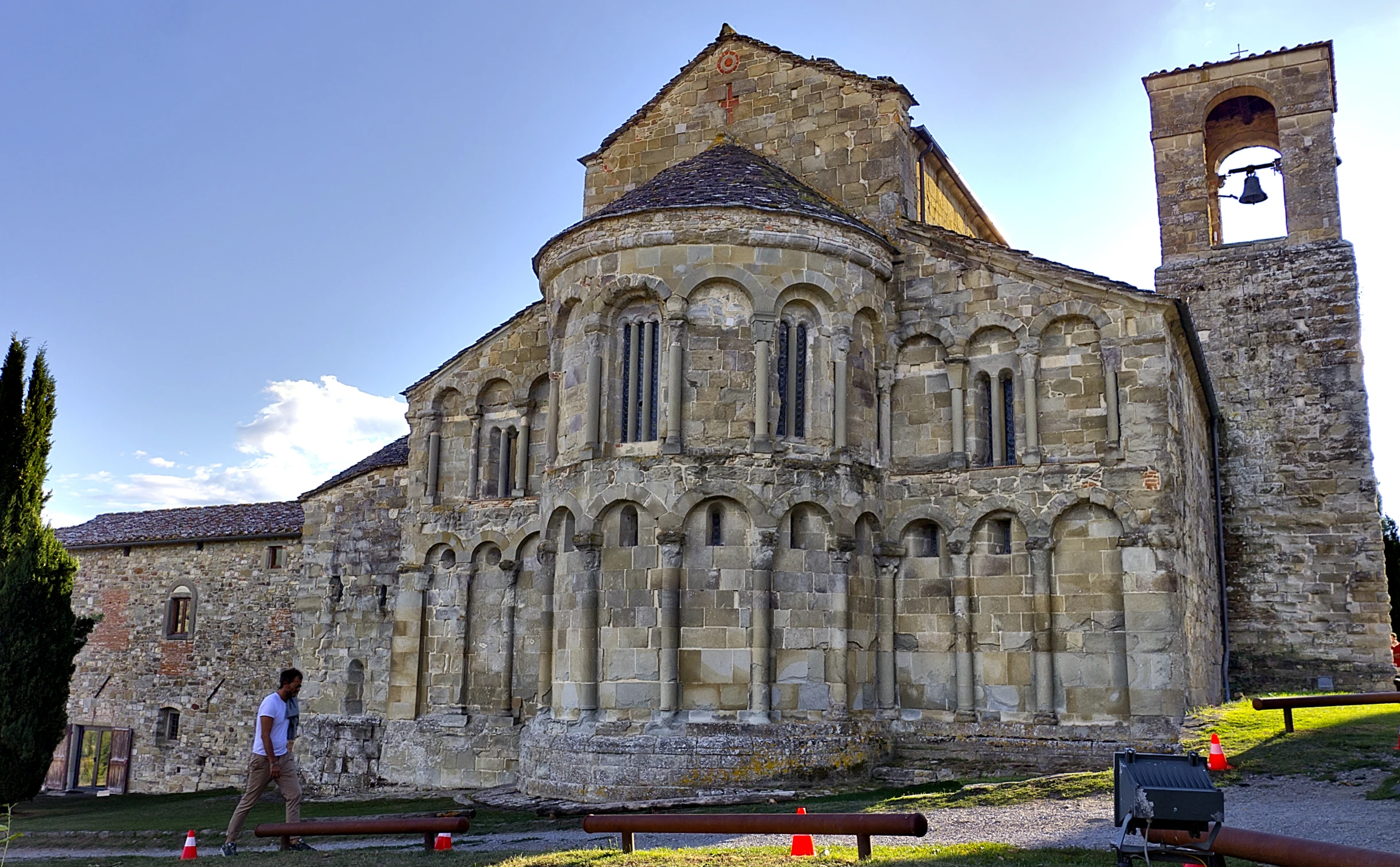 people are walking near an old building with two towers