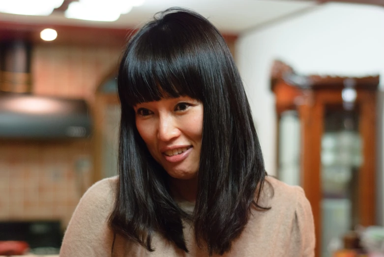 a close up of a woman in a kitchen smiling