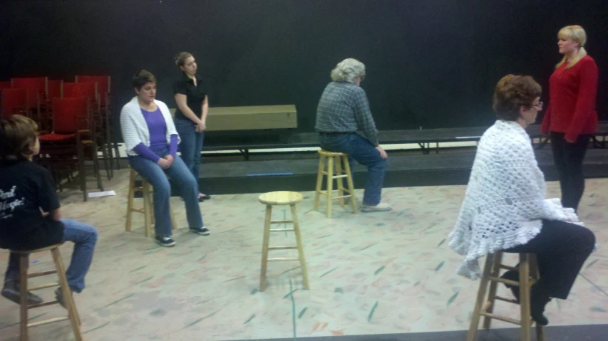 a bunch of women on stage talking to each other