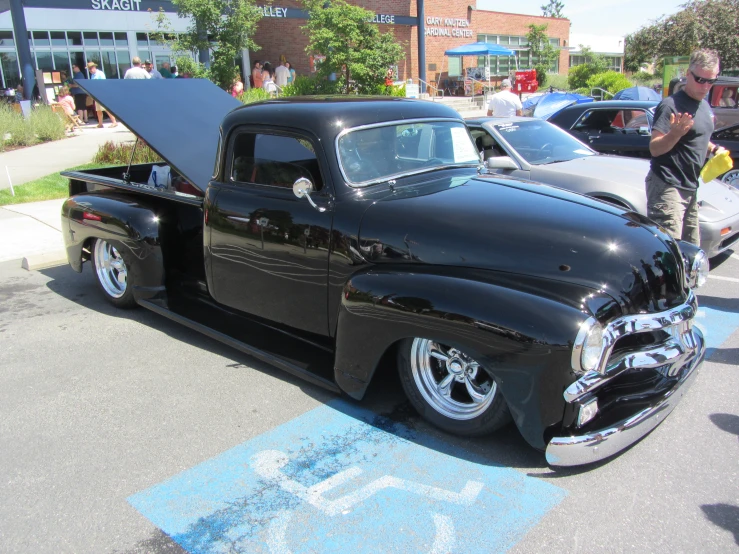 an old classic black truck parked on the side of the road