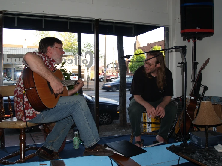 two musicians sit side by side in a room