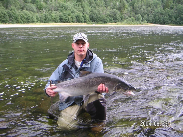 a man is holding a fish in the water