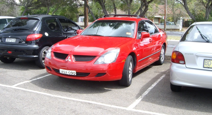 a close up of a red car in a parking lot