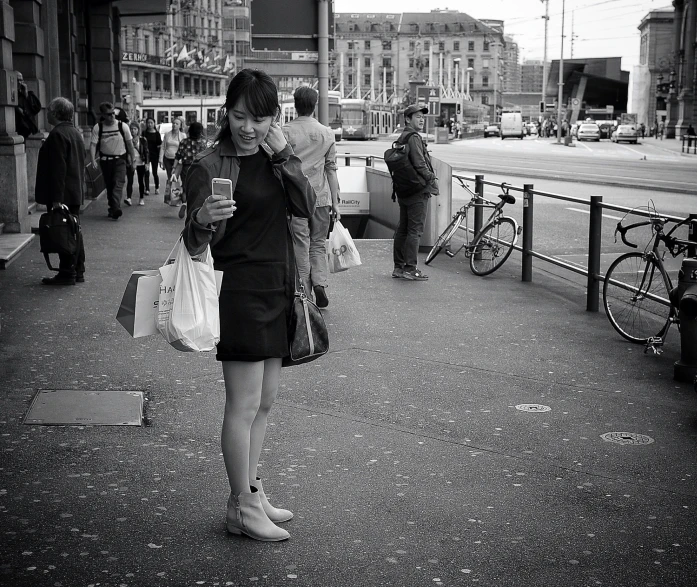 a woman is looking at her phone while she is holding her purse