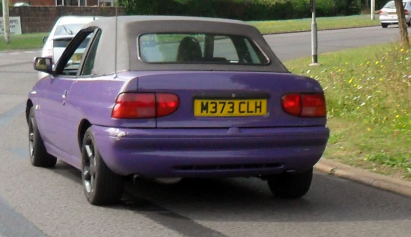 a purple car is parked in the middle of the road