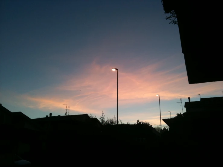 a bright sunset reflects in a cloudy sky over residential streets