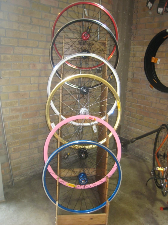 a tall metal rack holds lots of colorful bicycle rims