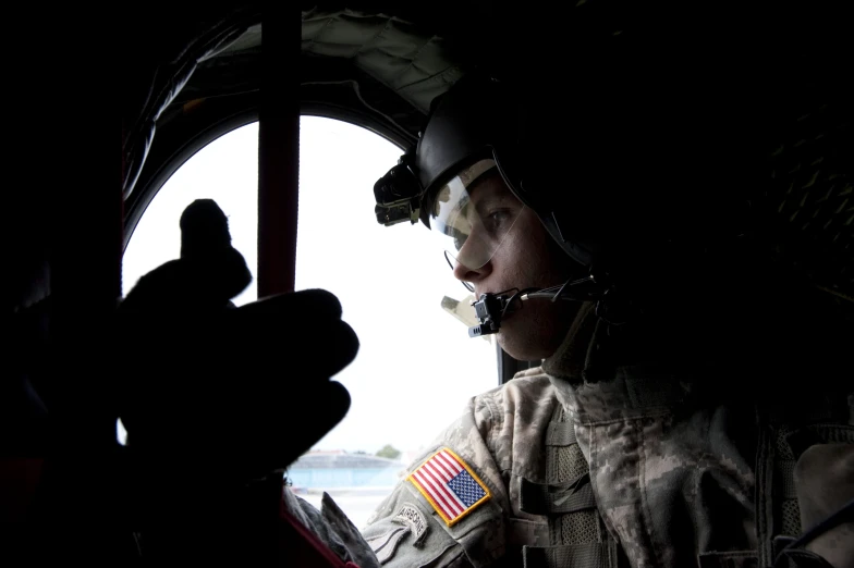 a man in the cockpit of a helicopter is shown in black