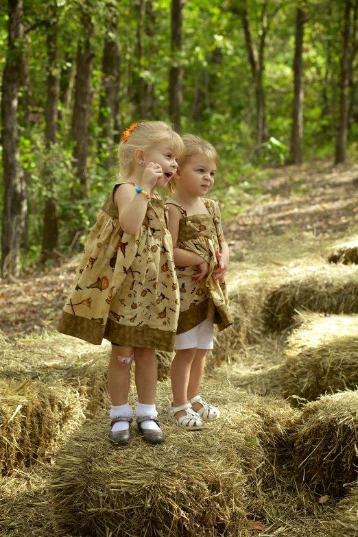 two little girls that are standing in the grass
