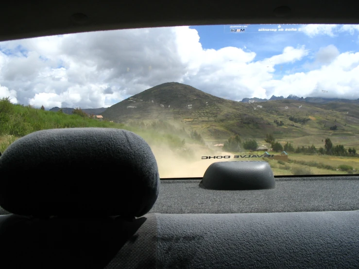 a picture taken from a vehicle windshield looking out at a mountain